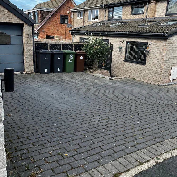 Grey block paved driveway in Alwoodley before pressure washing, with weeds in the joints