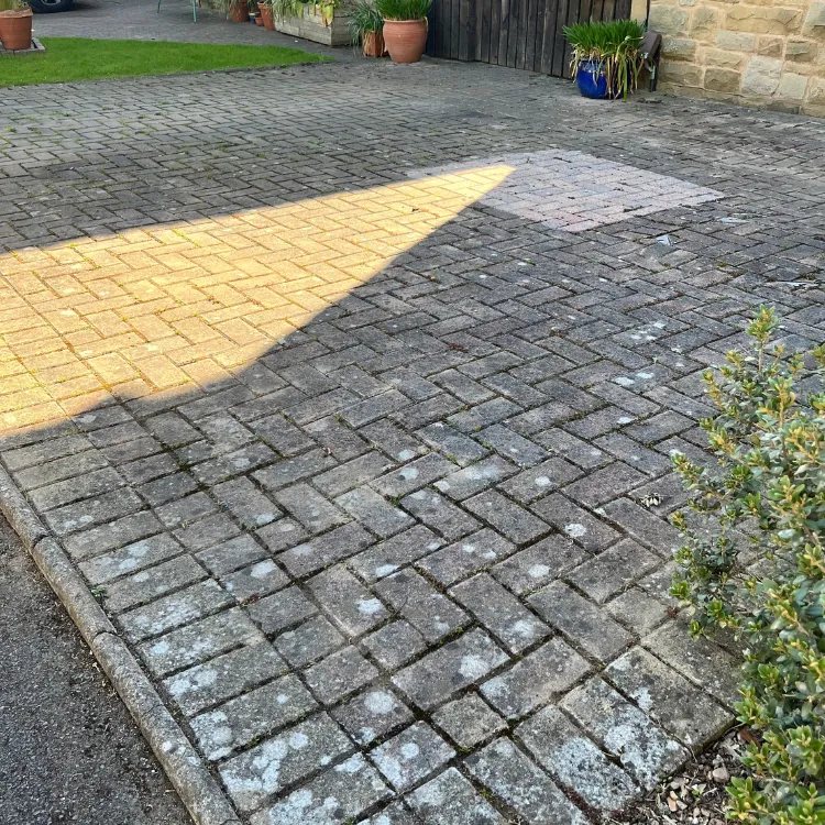 Block paved driveway in Roundhay before pressure washing, dark with algae and black spot
