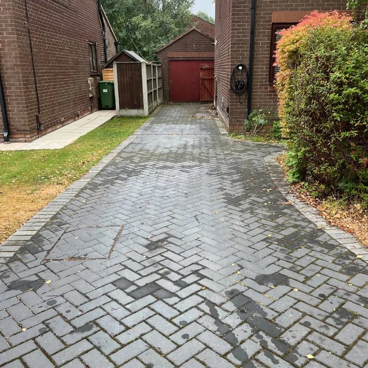 Charcoal block paved driveway in Shadwell before cleaning, patchy and dull