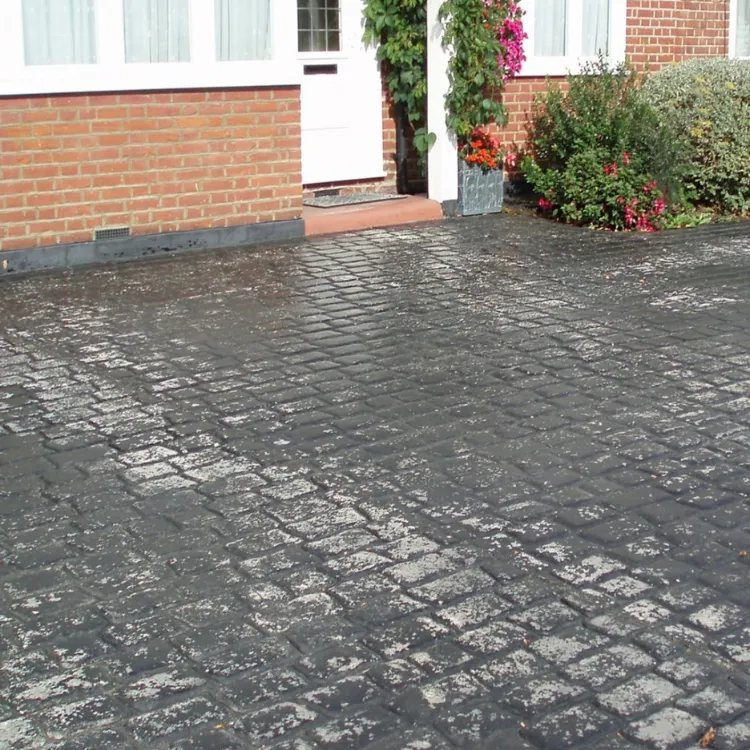 Cobble pattern imprinted concrete before recolouring, patchy and worn