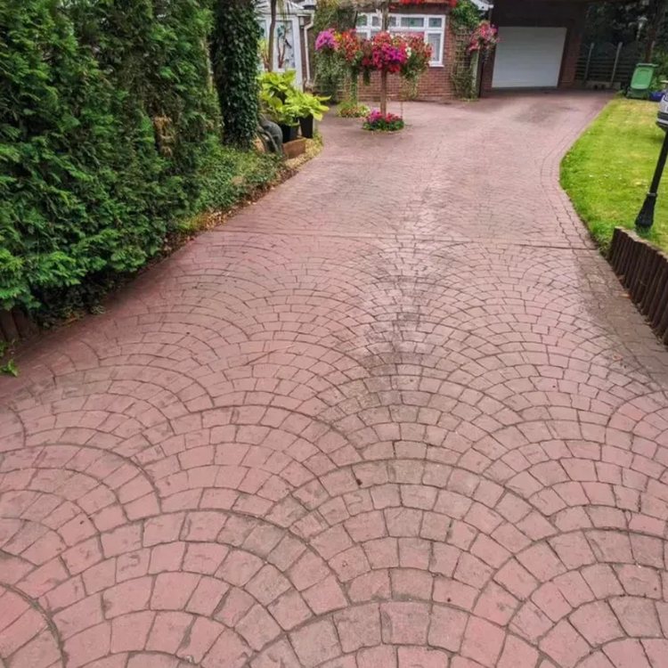 Red pattern imprinted concrete driveway before recolouring, faded to pink