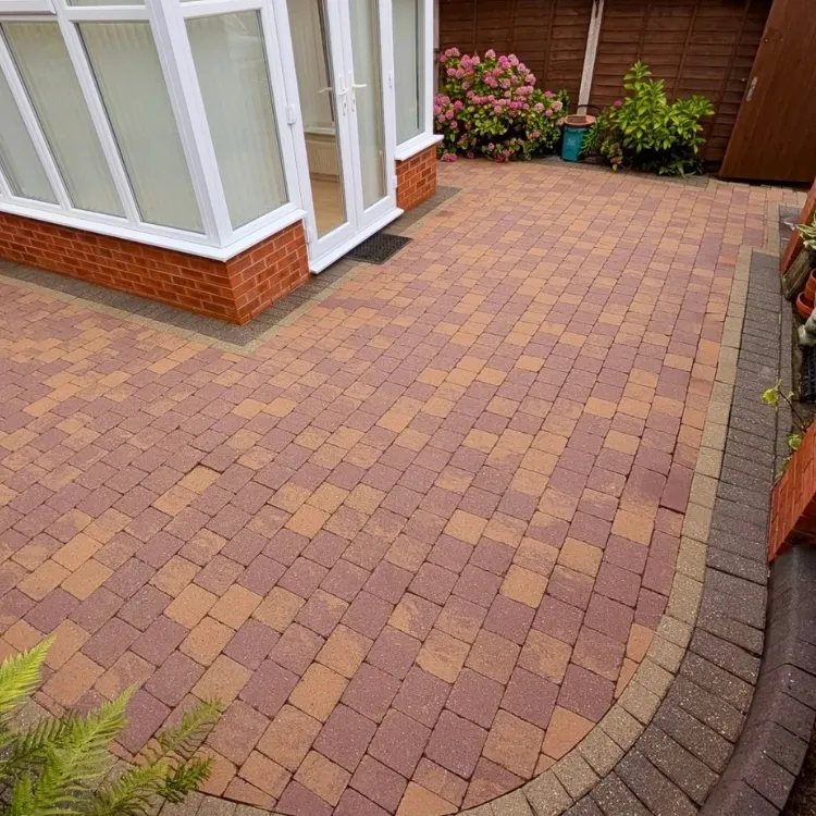 The same patio after jet washing, red and buff blocks showing again