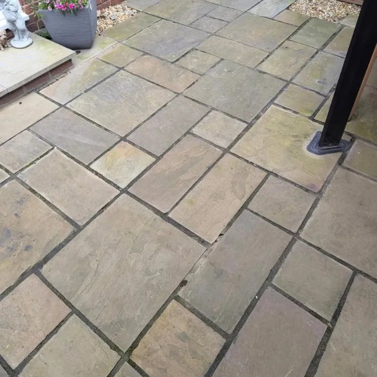 Indian sandstone patio before jet washing, dull and grey
