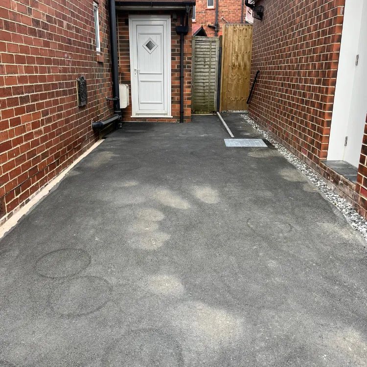 Tarmac yard at a back door before restoration, grey and marked
