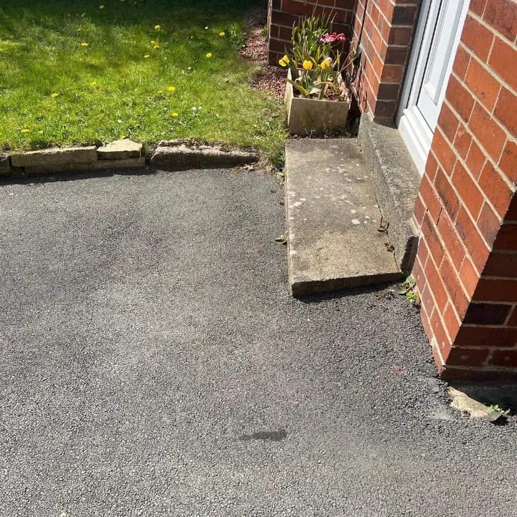 Faded tarmac beside a doorstep before restoration