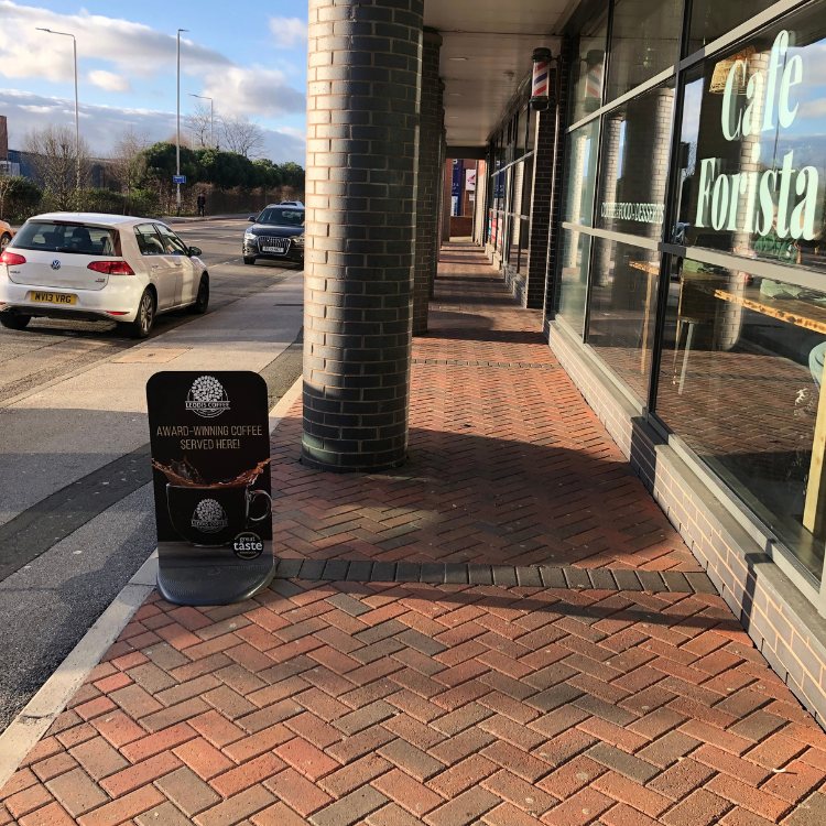 Clean red herringbone block paving outside a cafe