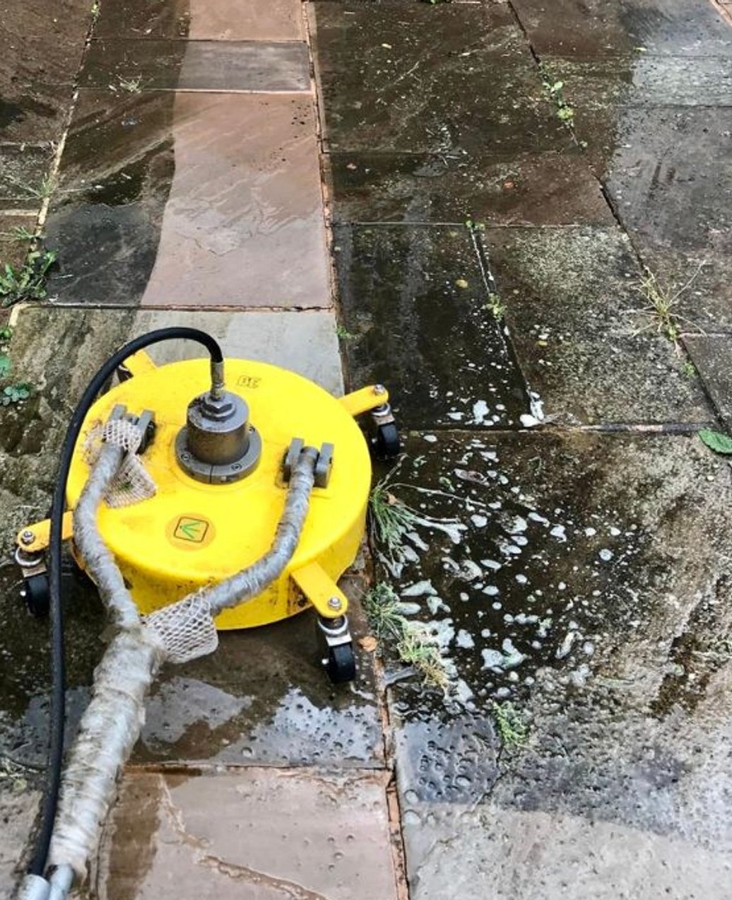 Indian sandstone patio being cleaned with a rotary surface cleaner