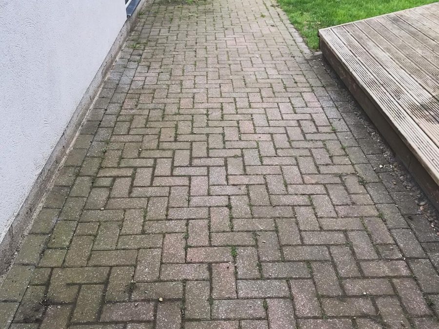 Block paved path in Leeds before pressure washing, green with moss and algae