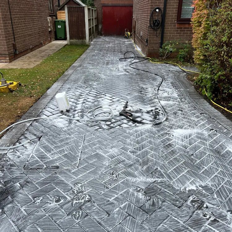 Cleaning treatment foaming on a charcoal block paved driveway